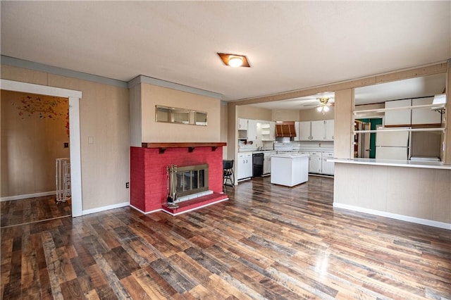 unfurnished living room with a fireplace, dark hardwood / wood-style floors, and ceiling fan