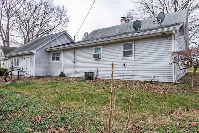 back of house with central AC and a yard