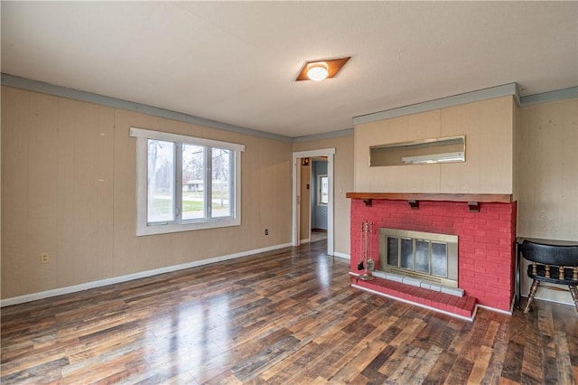 unfurnished living room with ornamental molding, dark wood-type flooring, and a brick fireplace