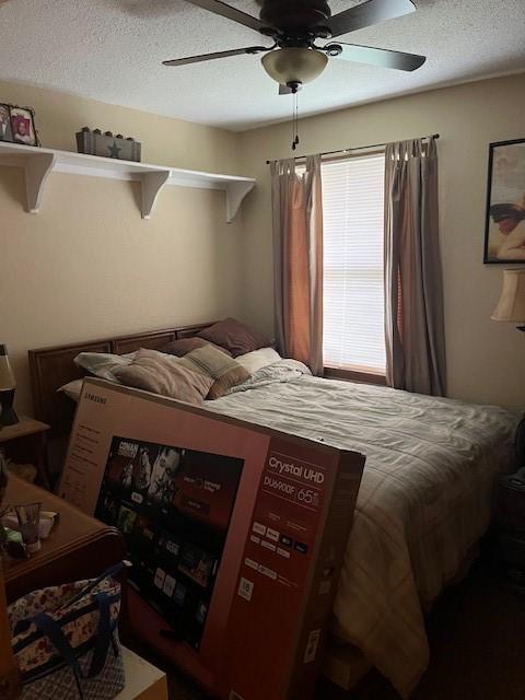bedroom with a textured ceiling and a ceiling fan