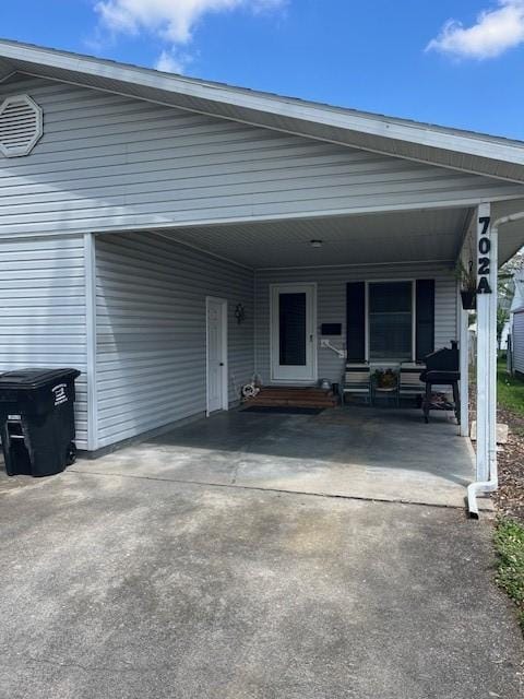 view of front of house with driveway, an attached carport, and entry steps