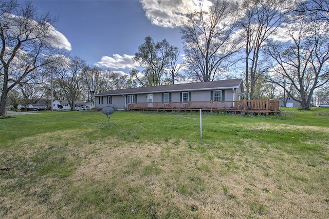 back of property with a yard and a wooden deck