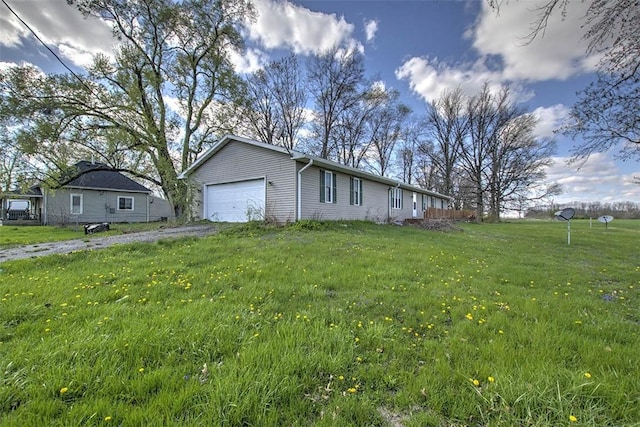 exterior space with a yard, a garage, and aphalt driveway