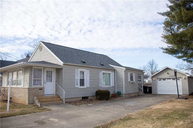 view of front of home featuring a garage, entry steps, concrete driveway, roof with shingles, and an outbuilding