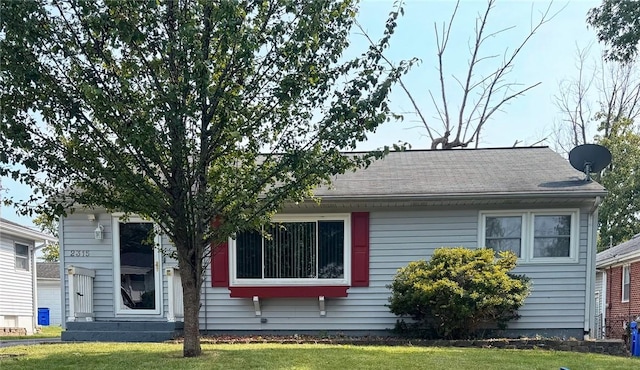 view of front of property with a front yard and a shingled roof
