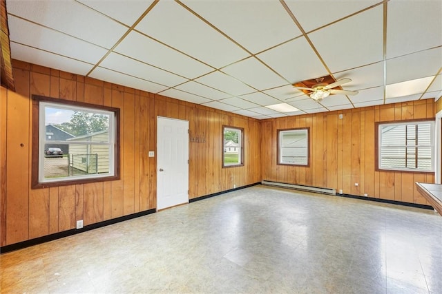 1609 10th St, Charleston, IL 61920 - empty room featuring baseboard heating, tile patterned floors, plenty of natural light, wood walls, and a ceiling fan