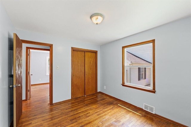 1609 10th St, Charleston, IL 61920 - unfurnished bedroom with wood finished floors and a closet