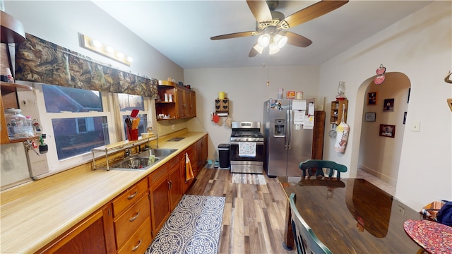 kitchen with ceiling fan, sink, stainless steel appliances, and light wood-type flooring