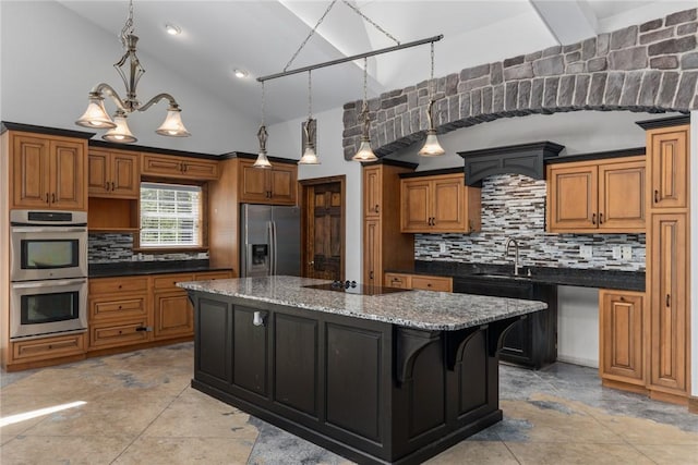 2098 2070th Ave, Saint Elmo, IL 62458 - kitchen featuring appliances with stainless steel finishes, decorative backsplash, a center island, brown cabinets, and dark stone countertops