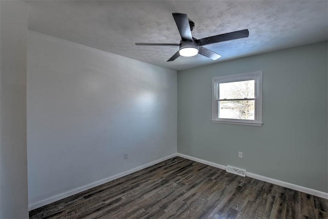 spare room featuring dark hardwood / wood-style flooring, ceiling fan, and a textured ceiling