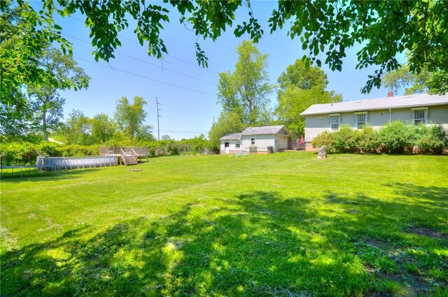 805 N 33rd St, Decatur, IL 62521 - view of grassy yard with a trampoline and a deck