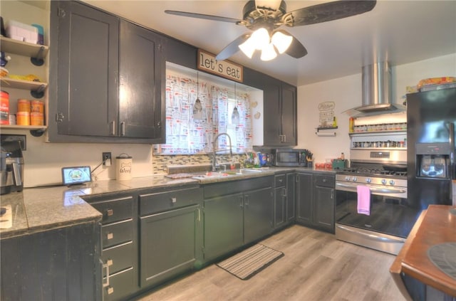 805 N 33rd St, Decatur, IL 62521 - kitchen featuring wall chimney exhaust hood, appliances with stainless steel finishes, a sink, a ceiling fan, and light wood-style floors