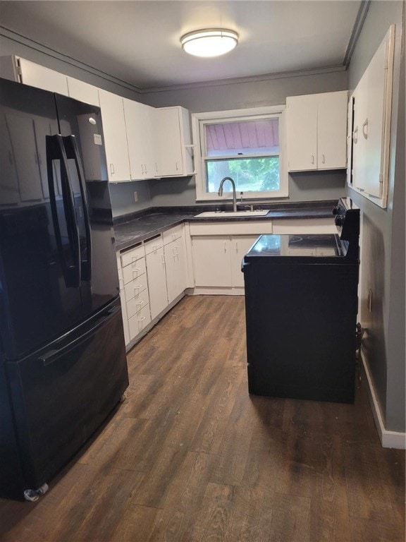 kitchen with white cabinetry, black refrigerator, and sink