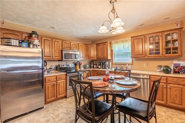510 W Illinois St, Assumption, IL 62510 - kitchen with appliances with stainless steel finishes, brown cabinetry, light countertops, and light tile patterned floors
