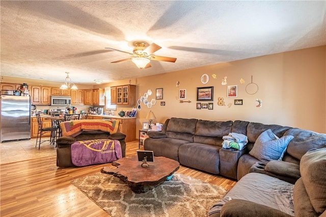 510 W Illinois St, Assumption, IL 62510 - living room with ceiling fan, light wood-style flooring, a textured ceiling, and a chandelier