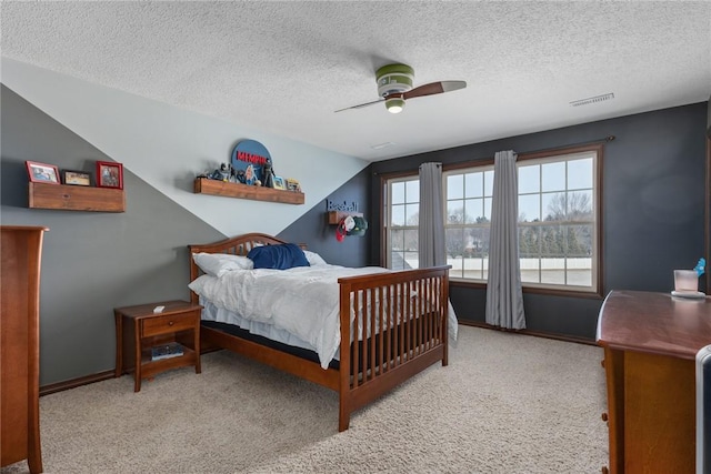 carpeted bedroom with ceiling fan and a textured ceiling