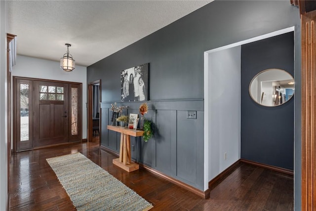 entrance foyer featuring a textured ceiling and dark hardwood / wood-style floors