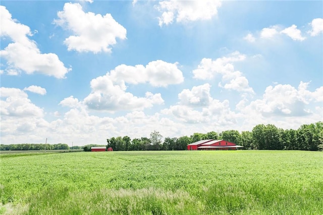 view of grassy yard with a view of countryside and an outbuilding