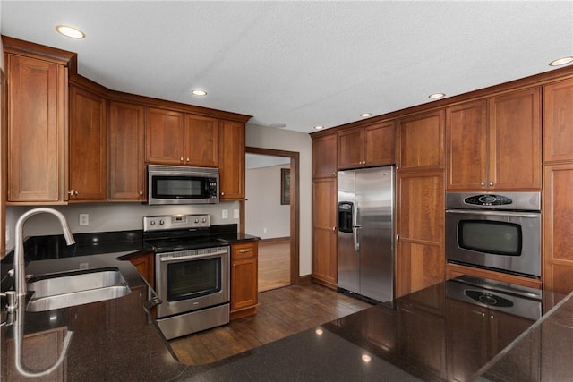 1025 Cardinal Dr, Effingham, IL 62401 - kitchen featuring appliances with stainless steel finishes, a warming drawer, recessed lighting, dark wood finished floors, and brown cabinetry