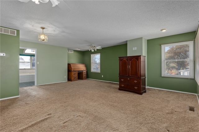 unfurnished living room with ceiling fan with notable chandelier, light colored carpet, and a textured ceiling