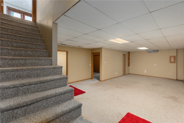 basement featuring light carpet and a drop ceiling