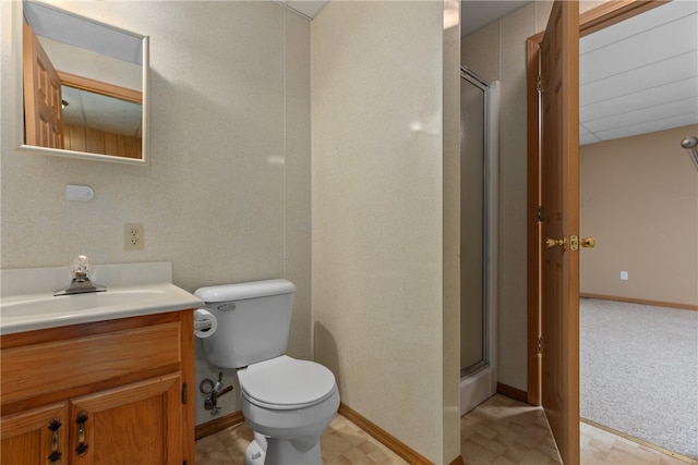 bathroom with a shower with door, vanity, and toilet