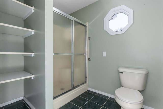 bathroom featuring tile patterned flooring, toilet, and an enclosed shower