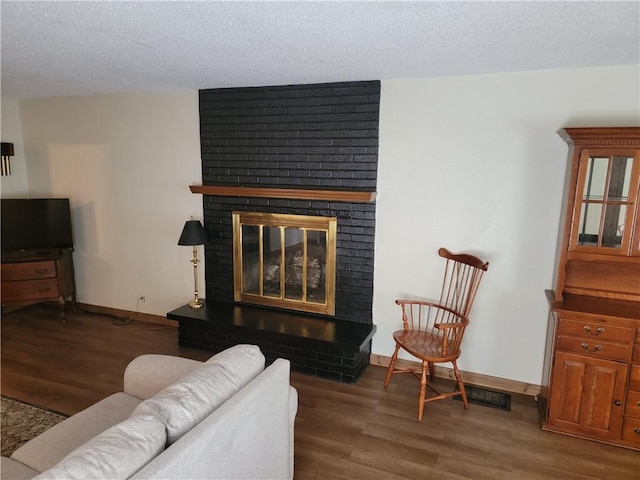 410 E Ninth St, Pana, IL 62557 - living room with a fireplace, wood finished floors, and a textured ceiling