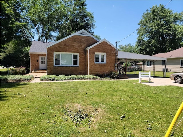 410 E Ninth St, Pana, IL 62557 - view of front facade with brick siding, a carport, and a front lawn