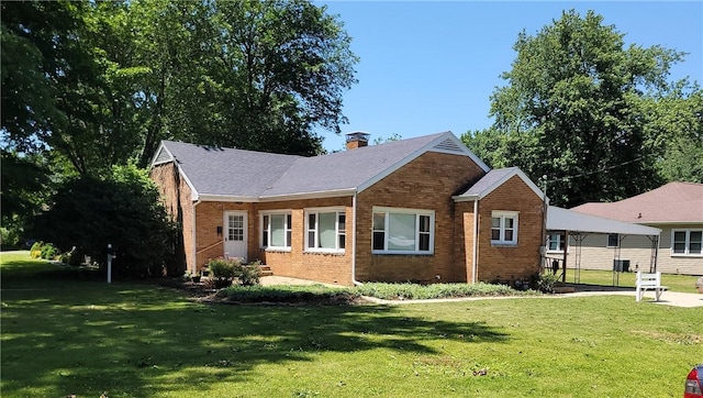 410 E Ninth St, Pana, IL 62557 - view of front of house featuring a front yard, brick siding, and a chimney