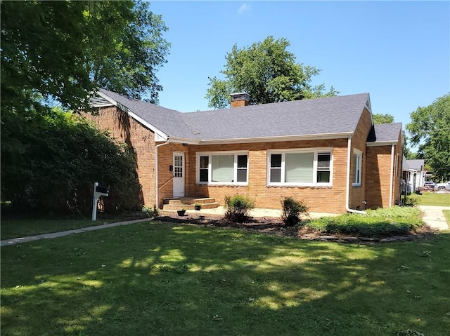 410 E Ninth St, Pana, IL 62557 - ranch-style home with brick siding, a front yard, a chimney, and roof with shingles