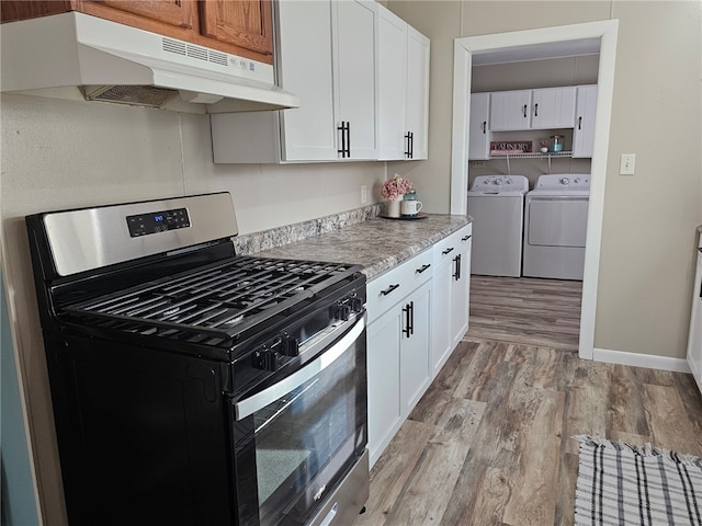 kitchen with stainless steel gas range oven, under cabinet range hood, light countertops, light wood-style flooring, and independent washer and dryer