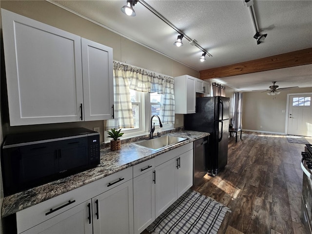 kitchen featuring a sink, a textured ceiling, dark wood finished floors, white cabinetry, and stainless steel appliances