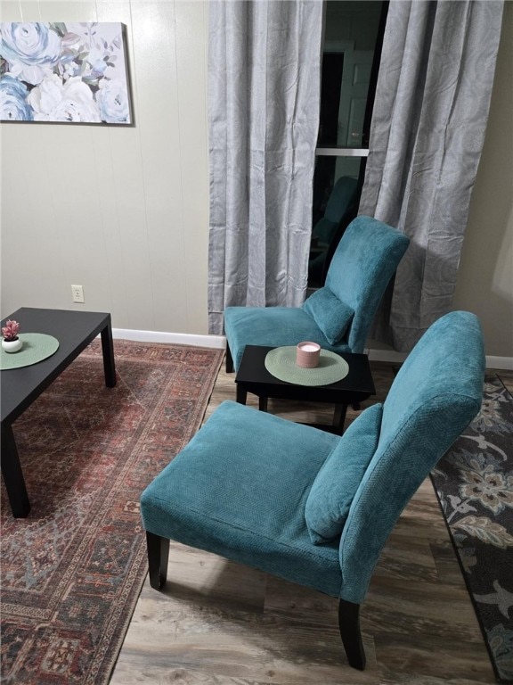 sitting room with baseboards and wood finished floors