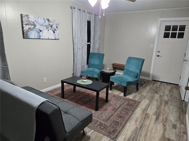 interior space featuring wood finished floors, baseboards, and ceiling fan