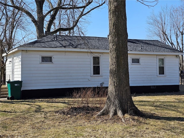 view of property exterior featuring crawl space, a yard, and a shingled roof