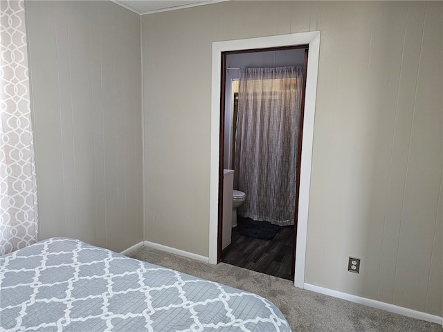 bedroom with ensuite bath, carpet flooring, and baseboards