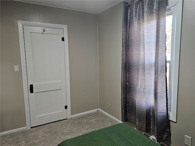 unfurnished bedroom with ornamental molding, baseboards, and carpet floors