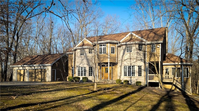 view of front of property featuring a garage, a sunroom, and a front lawn