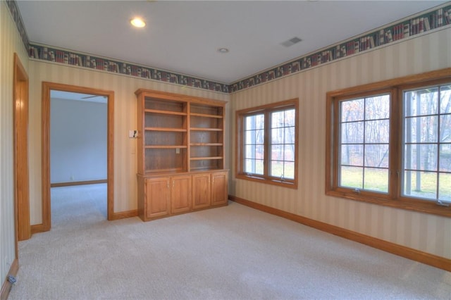 spare room with light carpet, baseboards, visible vents, and wallpapered walls