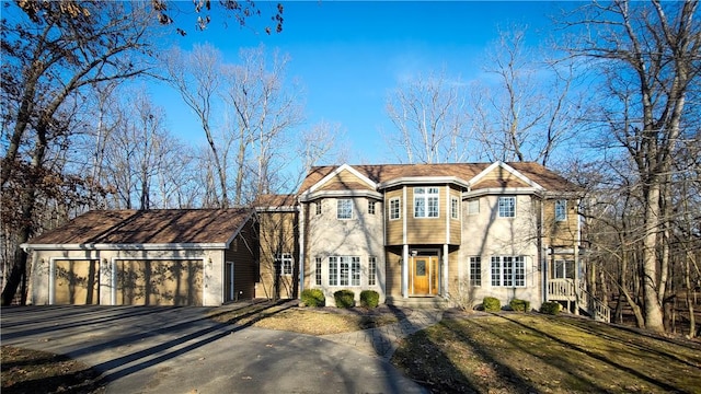 view of front of home with an attached garage, driveway, and a front lawn