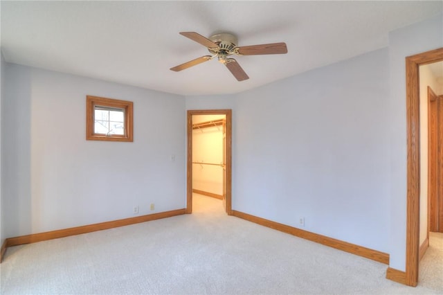 empty room featuring light carpet, ceiling fan, and baseboards