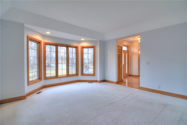 carpeted spare room featuring recessed lighting, visible vents, and baseboards