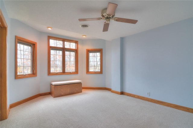 unfurnished room featuring a wealth of natural light, visible vents, and light colored carpet