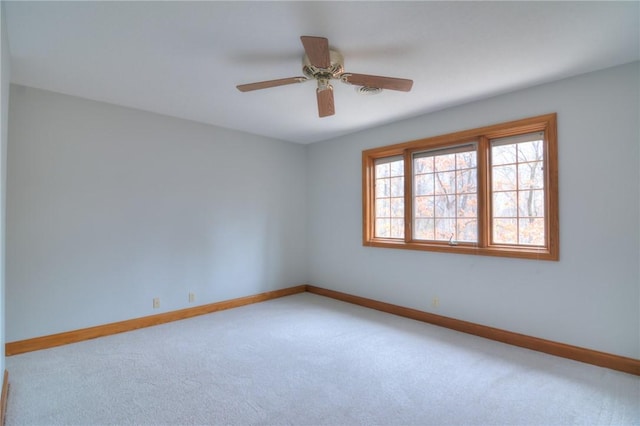 empty room with ceiling fan, carpet, and baseboards