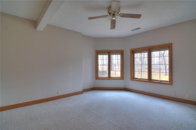 unfurnished room with carpet floors, a ceiling fan, visible vents, baseboards, and beamed ceiling