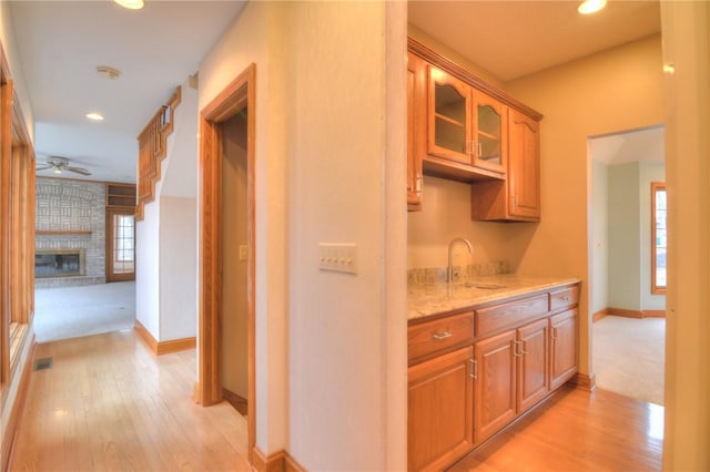 hall featuring recessed lighting, visible vents, a sink, and light wood finished floors