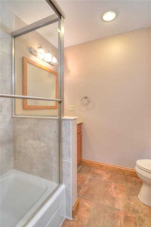 full bath featuring baseboards, vanity, toilet, and walk in shower