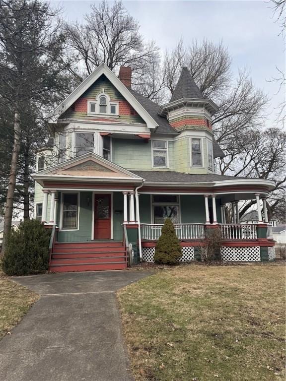 victorian-style house featuring a porch and a front yard