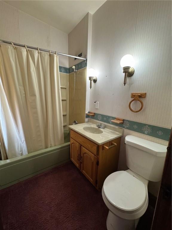 full bathroom with vanity, shower / tub combo with curtain, and toilet